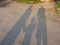 Shadows of mother and father holding their little baby`s hand lying on the ground