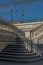 Shadows from old metal railings and a fence on semi-circular steps. Architectural geometry against the sky