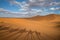 Shadows of tourist in a caravan riding dromedaries in the Sahara desert sand dunes near Merzouga