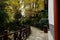 Shady fenced path near pond before tile-roofed buildings in woods