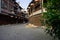 Shady flagstone-paved street between old-fashioned buildings in