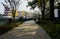 Shady riverside fenced path in city on sunny winter morning