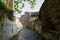Shady stone alley before tile-roofed building in ancient town
