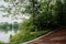 Shady waterside path in cloudy raining summer morning