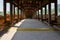 Shady wooden colonnade on arch bridge in sunny autumn