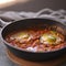 Shakshouka with avocado in a frying pan on a gray table close-up