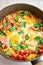 Shakshouka for breakfast. Homemade shakshuka, fried eggs, onion, bell pepper, tomatoes and parsley in a pan. Marble