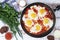 Shakshouka with five cooked eggs on top of tomato sauce in cast iron skillet