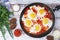 Shakshouka with five cooked eggs on top of tomato sauce in cast iron skillet