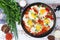 Shakshouka with five cooked eggs on top of tomato sauce in cast iron skillet