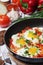 Shakshouka with five cooked eggs on top of tomato sauce in cast iron skillet