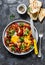 Shakshuka with baked sweet peppers and chickpeas on a dark background, top view