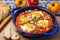 shakshuka in a blue ceramic dish with colorful napkins alongside