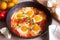 Shakshuka with bread on a wooden table. Middle eastern traditional dish. Homemade. Selective focus.