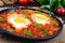 Shakshuka - a dish of eggs fried in a sauce of tomatoes, hot pepper, onions and seasonings.