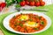 Shakshuka eggs on white plate with knife and fork