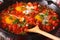 shakshuka fried eggs with sauce close up in a frying pan. horizontal