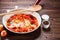 Shakshuka - fried eggs with vegetables in frying pan