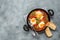 Shakshuka in a frying pan on a black stone rustic background. Poached eggs in a spicy tomato pepper sauce. Traditional