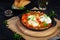 Shakshuka with grilled bread. Fried eggs with tomato, pepper, garlic and herbs