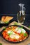 Shakshuka with grilled bread. Fried eggs with tomato, pepper, garlic and herbs