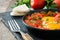 Shakshuka in iron frying pan on wood. Typical food in Israel.