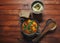 Shakshuka in pan with humus on a brown wooden background.