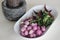 Shallots, curry leaves and red chillies ready to get pounded using Pestle and mortar