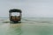 Shallow atoll sandbanks with lonely fisherman boat on low tide Nungwi beach in the Indian Ocean on the Zanzibar island, Tanzania.