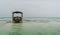 Shallow atoll sandbanks with lonely fisherman boat on low tide Nungwi beach in the Indian Ocean on the Zanzibar island, Tanzania.