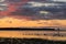 Shallow bay at sunset, with silhouetted flock of swans