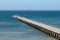 Shallow blue and green water surround a country jetty.