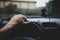 Shallow depth of field image with the hand of a driver on the steering wheel