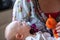 Shallow depth of field of Infant boy child with a pacifier, lies in his mothers arms with a orange knitted stuffed toy cat.