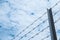 Shallow depth of field, old barbed steel wire against blue sky