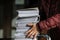 Shallow depth of field selective focus image with the hands of a man picking up a pile of files