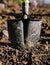 Shallow depth of field selective focus image with a metal shovel on a piece of agricultural plowed land