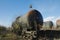 Shallow depth of field selective focus image with old and rusty railway oil tanker in the middle of a field on a sunny winter