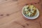 Shallow dish with ripe cherimoya fruit Annona cherimola on a wood table