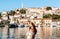 Shallow focus closeup of a female standing on the riverbank with buildings and towers in Umag