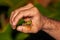 Shallow focus closeup shot of a red-eyed forest frog on a thumb of a male\'s hand