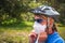 Shallow focus of a female cyclist wearing a helmet, sunglasses, and a facemask - COVID-19