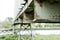 Shallow focus, high contrast of a weathered metal conveyor system, spanning a river.