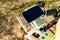 Shallow focus of male hands holding a remote controller of a drone on blurred background of a field