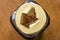 Shallow focus of a newly opened, instant coffee jar showing a tea spoon in the dried granules.