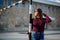 Shallow focus of a pretty young woman in a purple mock neck sweater posing beside a metal pole