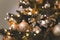 Shallow focus shot of beautiful baubles and string lights hanging on a Christmas tree
