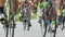 Shallow focus shot of cyclists lower bodies while riding bikes in cycling race. The bicycle wheel is spinning. Bicycle