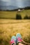 Shallow focus shot of the feet of a hiker sitting on grass on top of a hill and enjoying the view