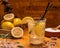 Shallow focus shot of a glass of lemonade with ice cubes, plastic straws, lemon slices, and sugar